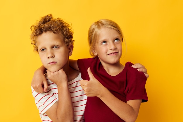 Ragazzo e ragazza coccole moda infanzia intrattenimento sfondo giallo