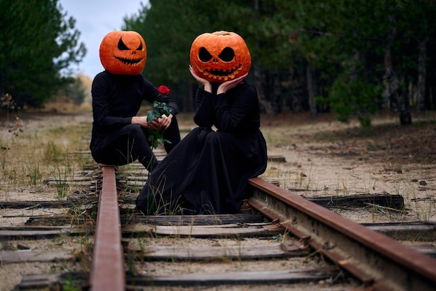 Ragazzo e ragazza di Halloween con le zucche sulle loro teste