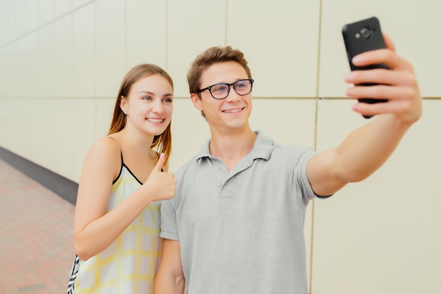 Ragazzo e ragazza sorridenti che prendono un selfie sul telefono cellulare