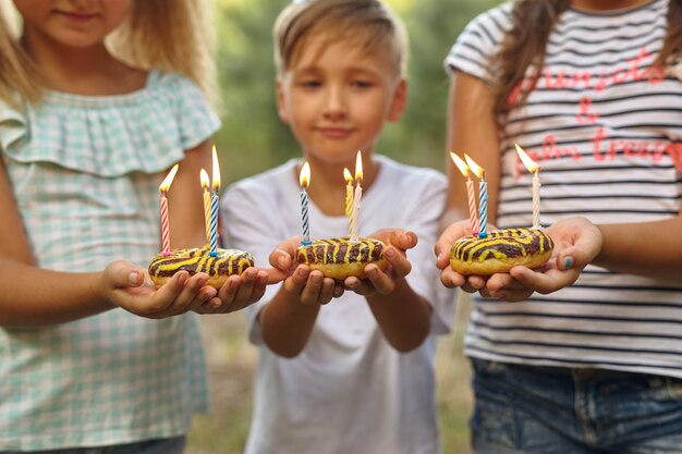 Ragazzo e ragazze che festeggiano il compleanno all'aperto in giardino