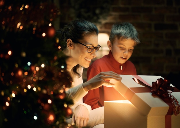 Ragazzo e sua madre che aprono i regali di Natale