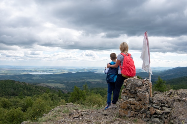 ragazzo e sua madre in piedi sulla cima della montagna