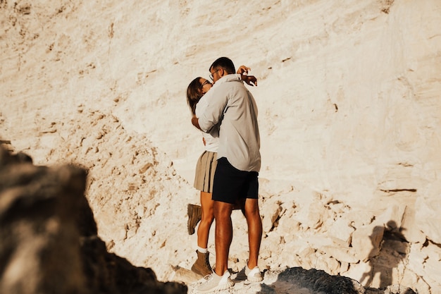 Ragazzo e una ragazza si stanno abbracciando vicino a pietre bianche