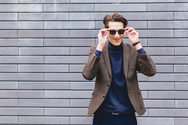 Ragazzo elegante in giacca e occhiali da sole