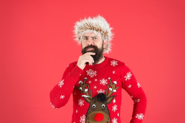 Ragazzo emotivo Previsioni del tempo Moda invernale Cure invernali Giorni freddi Servizi di barbiere Uomo con barba lunga e baffi Umore invernale Hipster barbuto indossa maglione lavorato a maglia e cappello di pelliccia