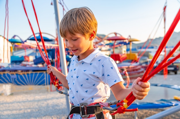 Ragazzo emozionante di Smilling che salta su un trampolino con assicurazione.