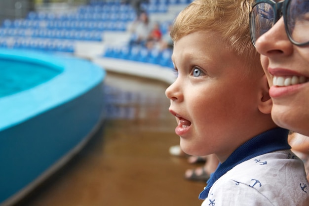 Ragazzo felice che guarda lo spettacolo in piscina con sua madre