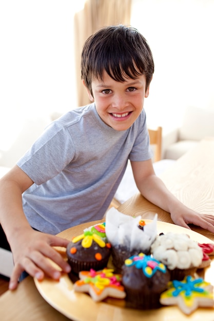 Ragazzo felice che mangia confetteria variopinta