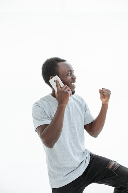 Ragazzo felice che parla sul suo telefono cellulare. isolato su sfondo bianco