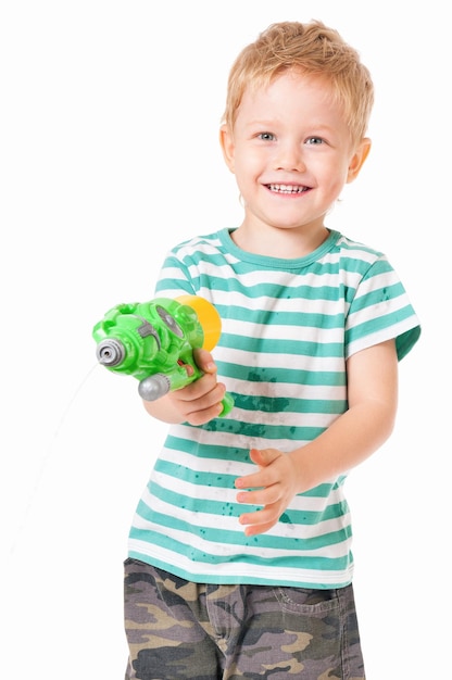 Ragazzo felice con pistola ad acqua in plastica isolato su sfondo bianco