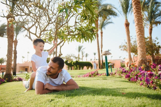 Ragazzo felice del bambino e del papà che gode in un parco soleggiato.