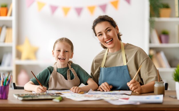 Ragazzo felice e insegnante a lezione di arte Donna e bambino stanno dipingendo insieme