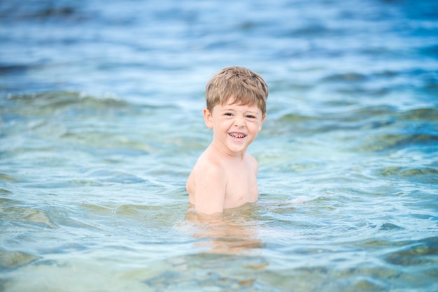 Ragazzo felice nel mare in estate.