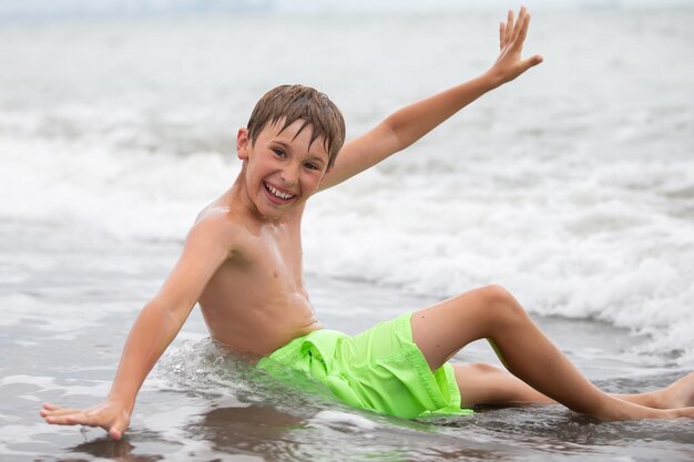 Ragazzo felice nuota al mare guarda nella telecamera riposo estivo