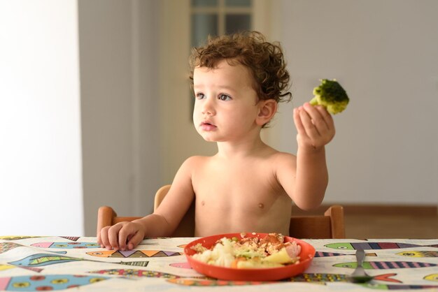 Ragazzo felice seduto a tavola a casa