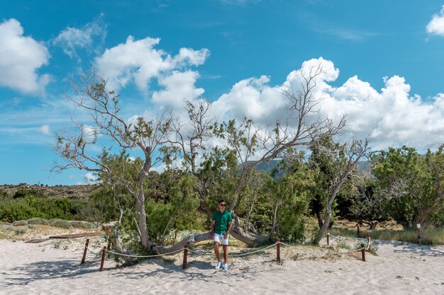 Ragazzo felice sulla spiaggia in pantaloncini e maglietta