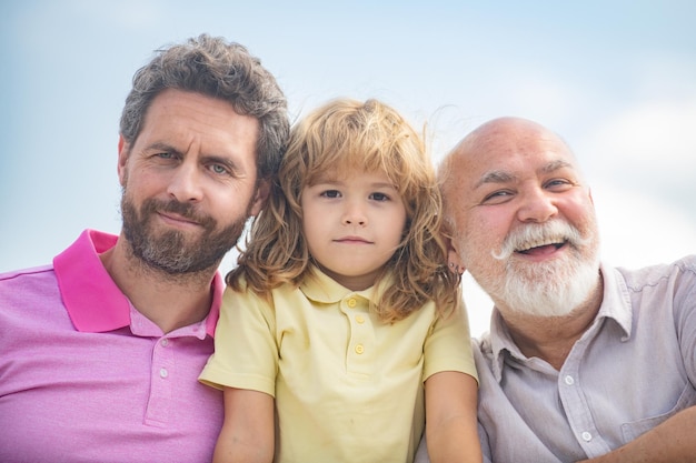 Ragazzo figlio con padre e nonno all'aperto primo piano ritratto Festa del papà Uomini di età diverse