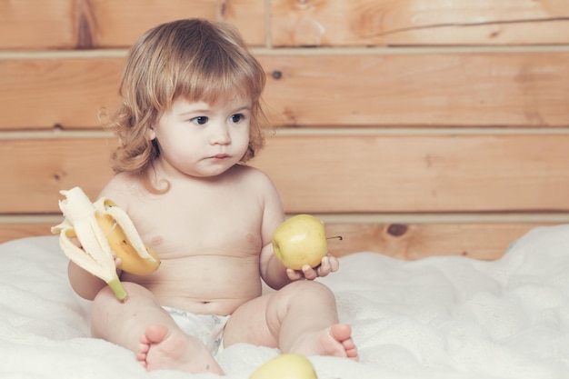 Ragazzo giocoso sorridente felice bello sveglio del bambino con i capelli bagnati che si siedono nel bagno lanuginoso bianco del bagno della serra