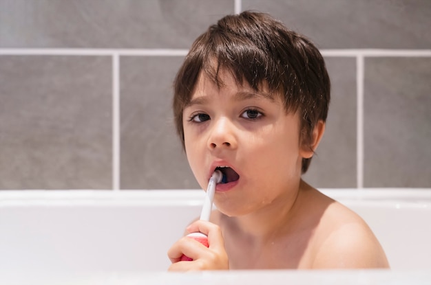 Ragazzo giovane lavarsi i denti mentre si fa il bagno