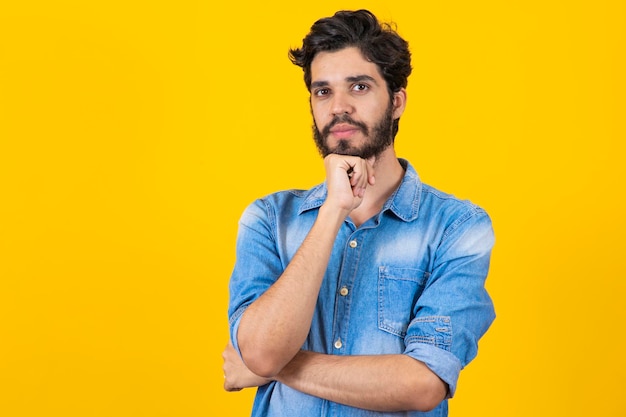 Ragazzo giovane studente premuroso su sfondo giallo giovane uomo pensando e avendo un'idea