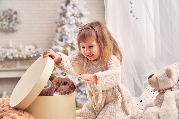 ragazzo ha un animale domestico per Natale. la stanza dei bambini è decorata con un albero di Natale.