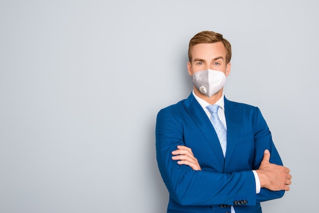 ragazzo imponente che indossa un braccio piegato con maschera respiratoria riutilizzabile