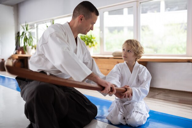 Ragazzo in ascolto. Ragazzino dai capelli biondi che ascolta il suo insegnante di aikido seduto vicino alla finestra