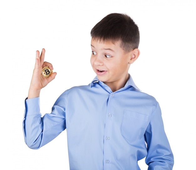 Ragazzo in camicia blu guarda con sorpresa il bitcoin in mano