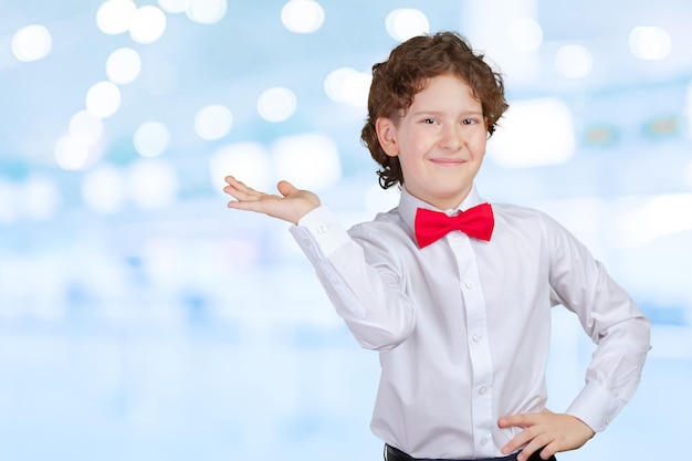 Ragazzo in camicia che indica con il palmo della mano