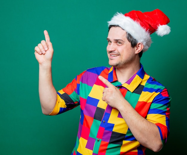 Ragazzo in cappello di Natale e camicia vintage sul verde