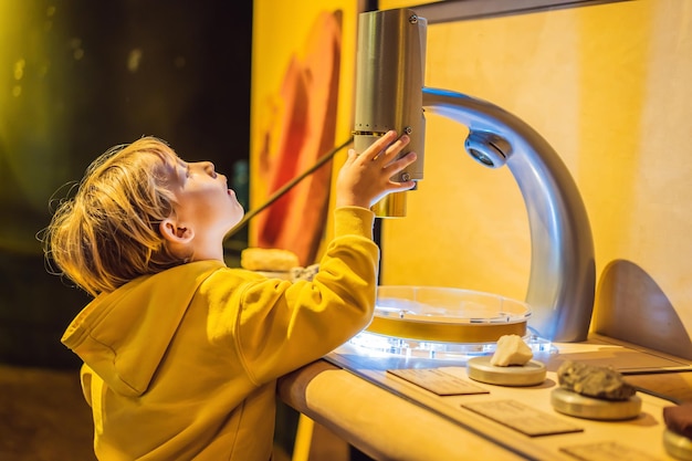 Ragazzo in classe di scienze con microscopio elettronico