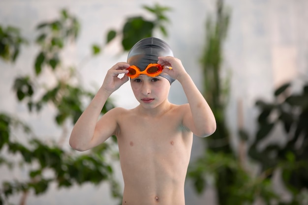 Ragazzo in cuffia nella piscina sportiva.