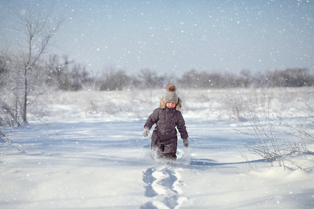 ragazzo in età prescolare che attraversa cumuli di neve