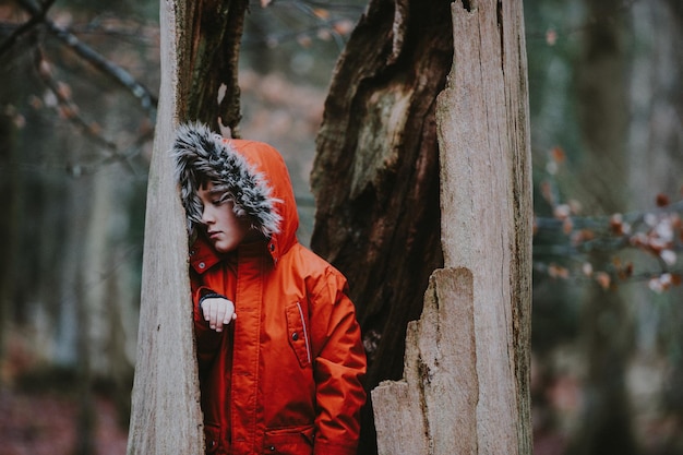 Ragazzo in piedi all'interno del tronco dell'albero