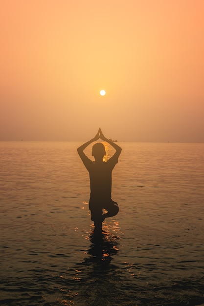 ragazzo in piedi posizione yoga su