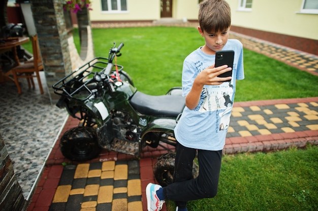 Ragazzo in quad quad ATV con telefono cellulare