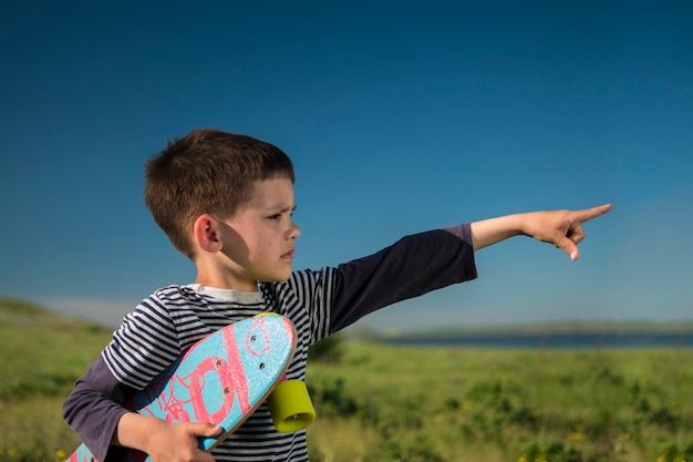 Ragazzo in una maglia con uno skateboard colorato