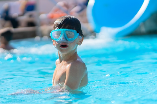 Ragazzo in una piscina all'aperto in un resort tropicale.