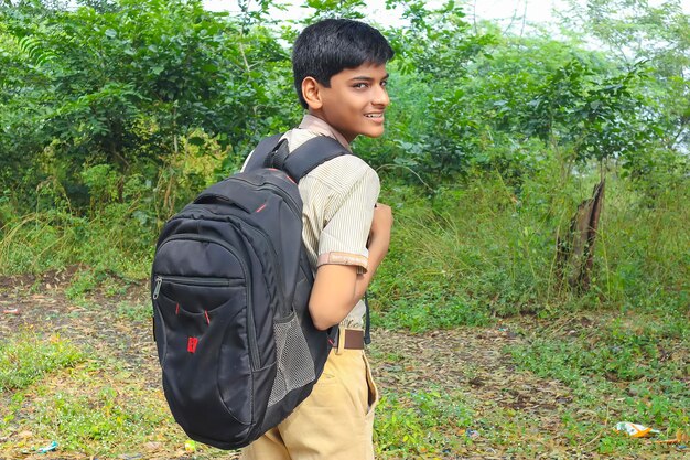 Ragazzo indiano della scuola che sta sopra lo sfondo della natura