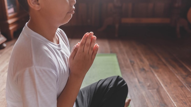 Ragazzo meditando con le mani in posizione di preghiera