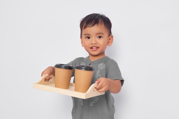 Ragazzo musulmano asiatico sorridente che tiene tazza di caffè o tè di carta isolato su sfondo bianco studio