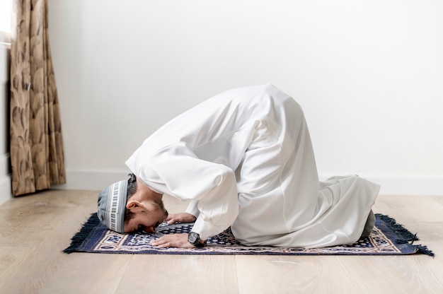 Ragazzo musulmano che prega nella posizione di Sujud