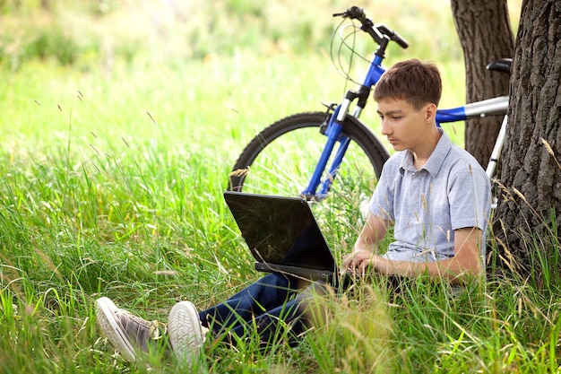 Ragazzo nel parco con laptop