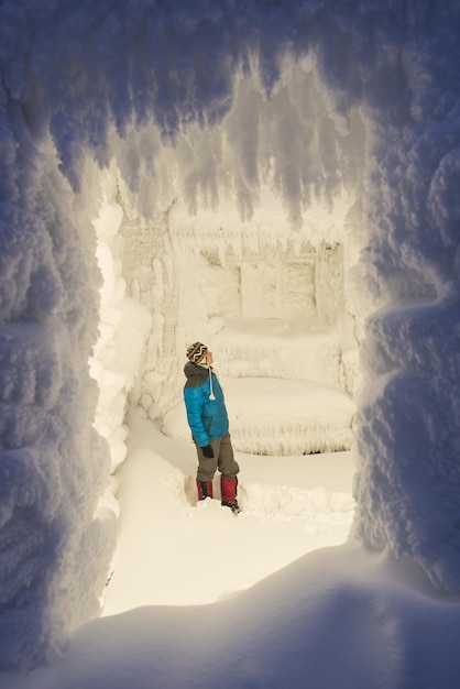 Ragazzo nella stanza invernale da favola con la brina