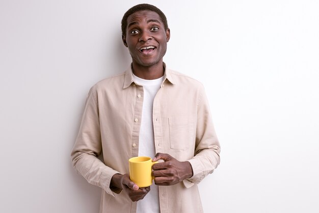 Ragazzo nero sorridente con una tazza di caffè al mattino