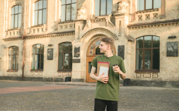 Ragazzo positivo in abiti casual che beve caffè durante la pausa