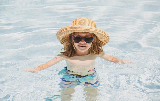 Ragazzo ragazzo nuota in piscina ragazzo carino nell'acqua che gioca con l'acqua