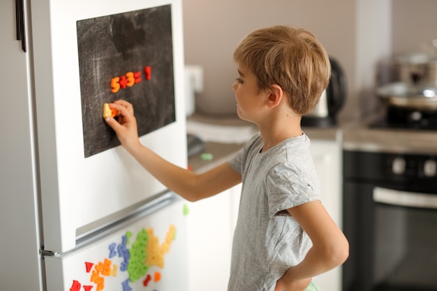 ragazzo risolve la matematica a casa su un tavolo da disegno