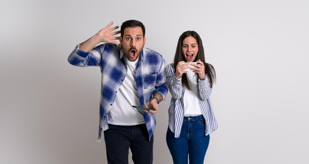 Ragazzo scioccato con la testa in mano che guarda la fotocamera dopo aver perso il videogioco con la ragazza