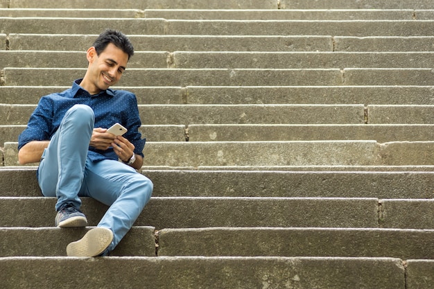 Ragazzo seduto sulle scale con il telefono